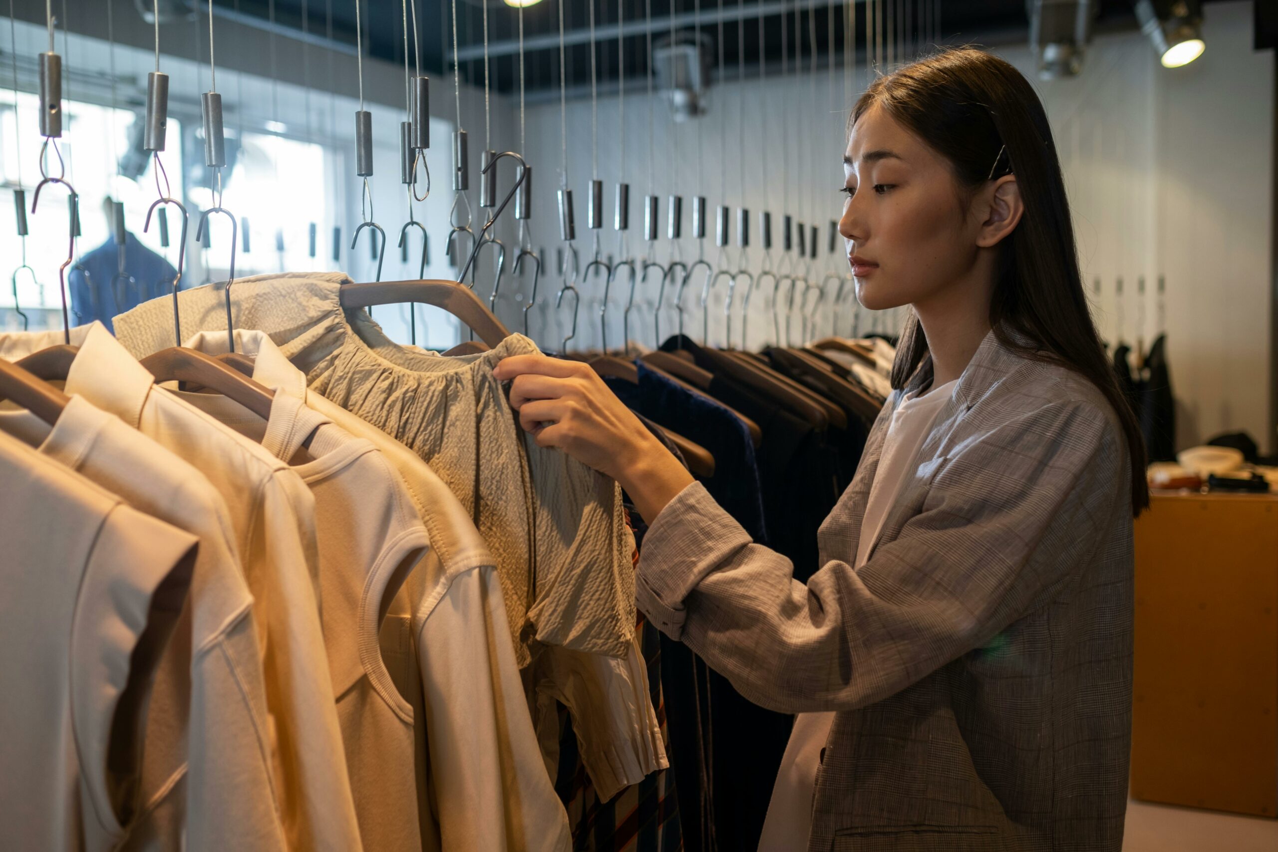 Woman looking at neutral color cothing for her capsule wardrobe