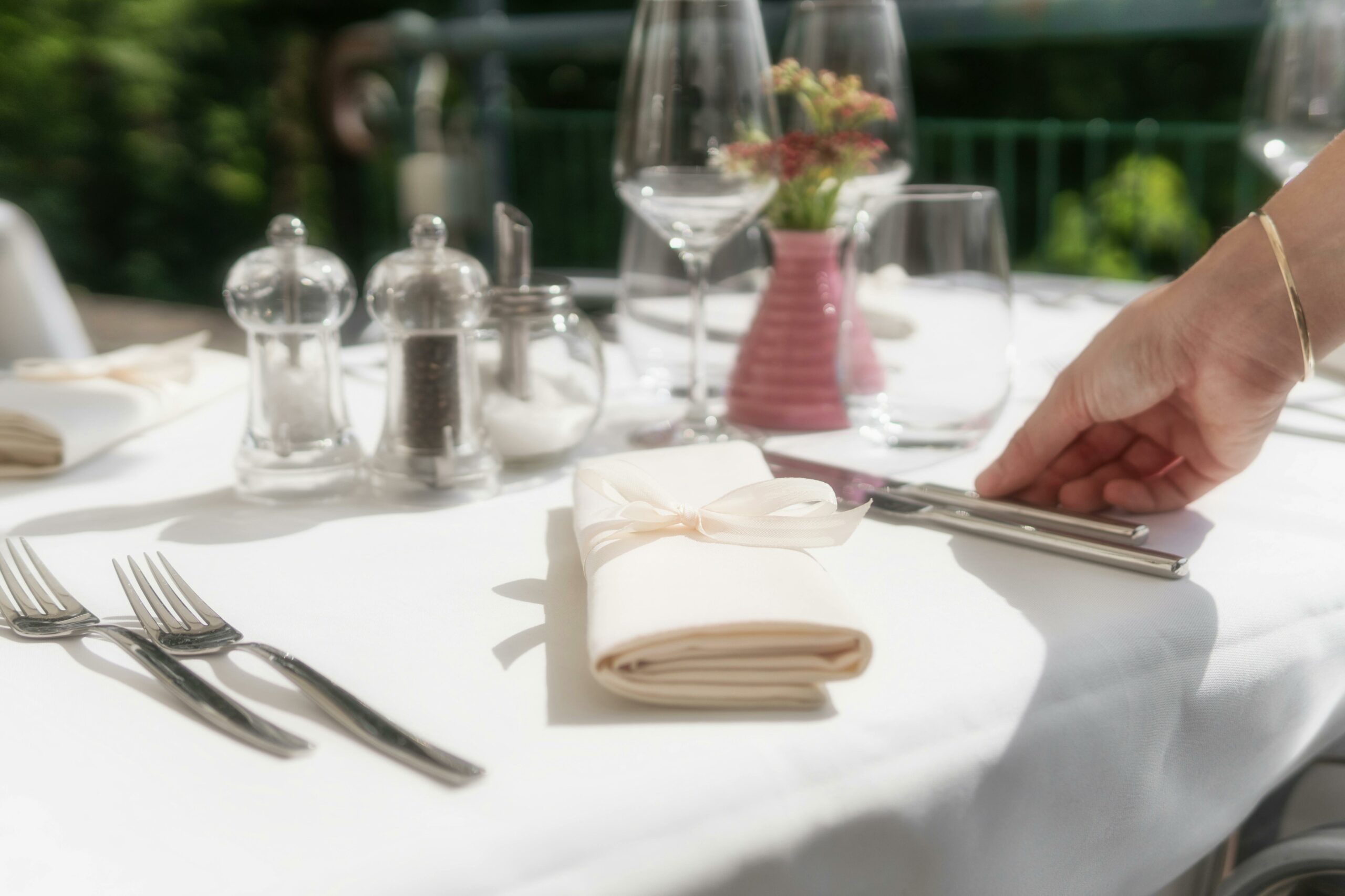 Setting up tablescape by adding tableware and cutlery