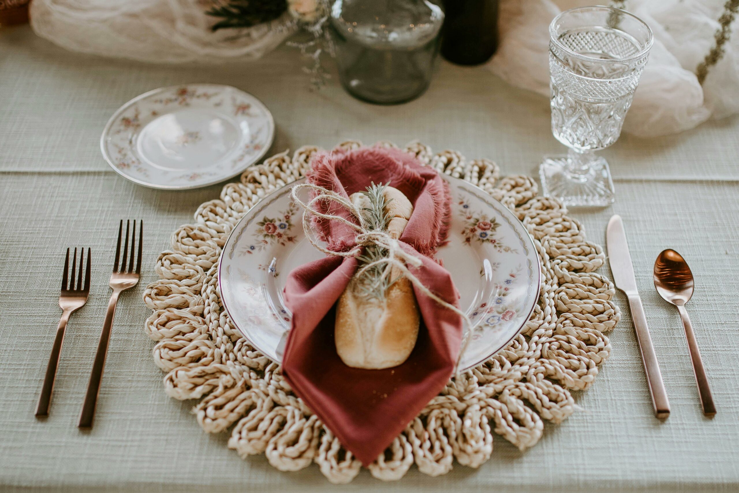 tablescape details, seagrass placemat, linen napkins, with golden cutlery