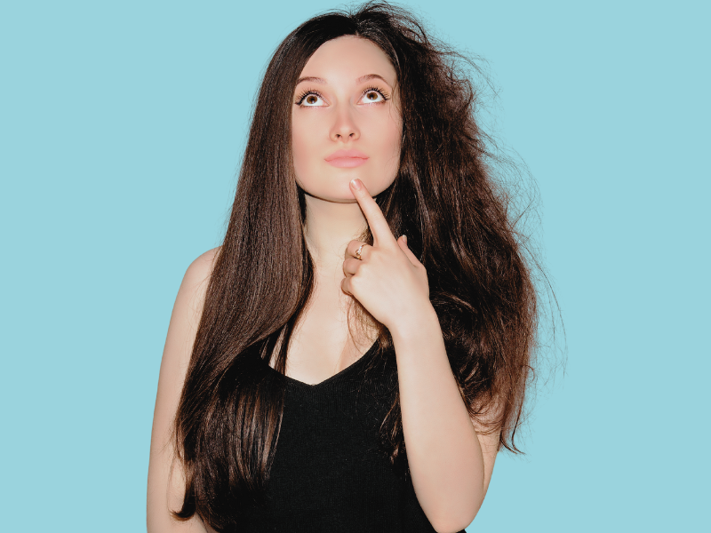 a woman with long brown hair and a blue background wondering what her hair type is