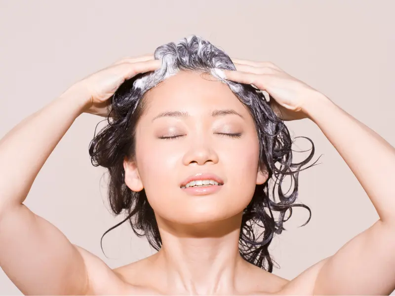 Asian woman washing her her with shampoo